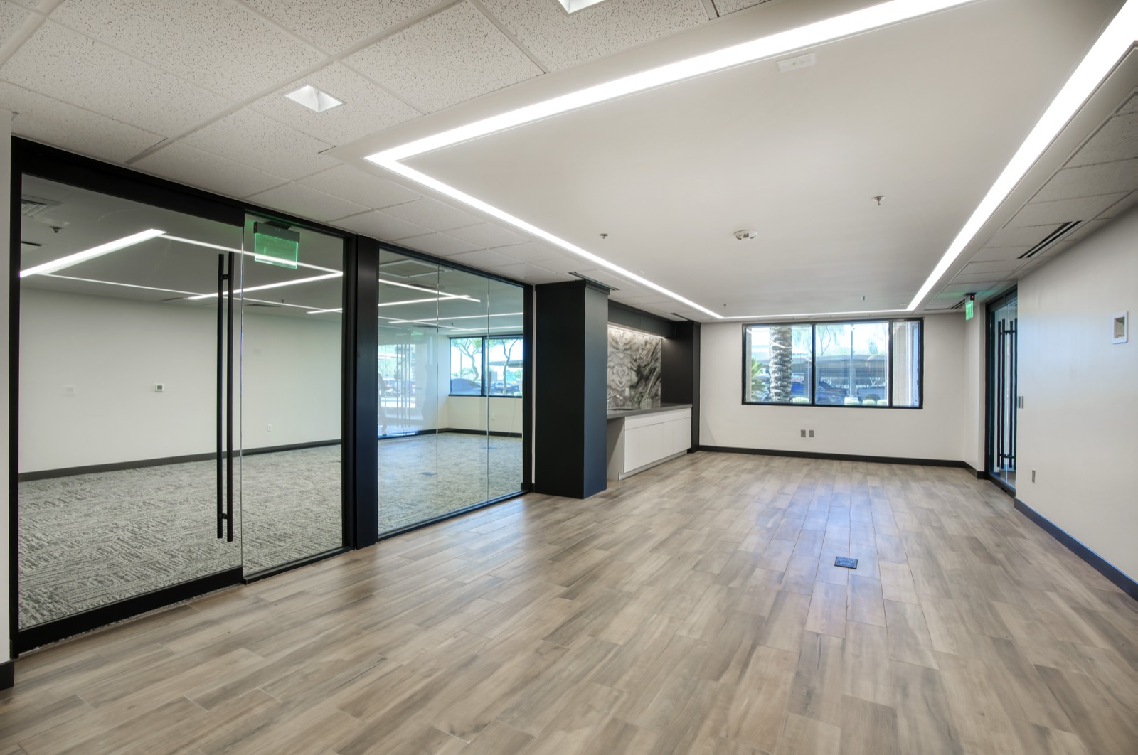 Open common area with glass conference room — office build-out in Phoenix by JMG Contracting